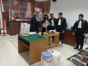 Sudirman Situmeang menunjukkan barang bukti kepada terdakwa Murthy Sockalingam dalam persidangan. (foto: JP - BATAMPENA)