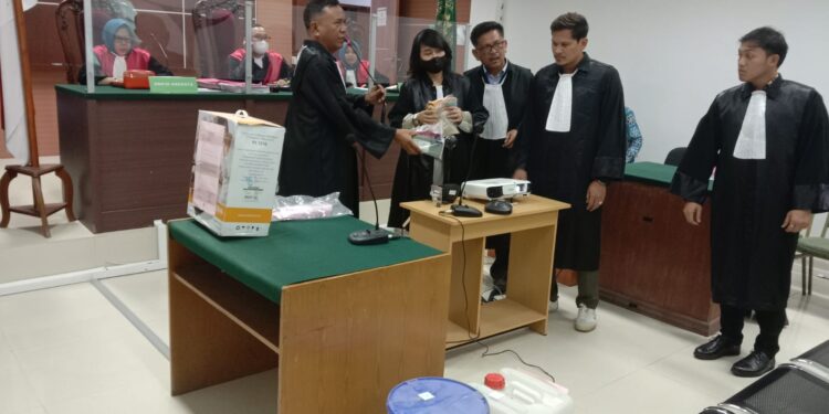 Sudirman Situmeang menunjukkan barang bukti kepada terdakwa Murthy Sockalingam dalam persidangan. (foto: JP - BATAMPENA)