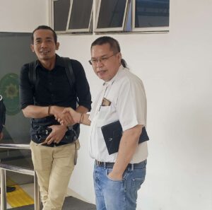 Advokat Hermanto Tambunan bersalaman dengan Advokat Niko Nixon Situmorang selaku penasehat hukum Roma Nasir Hutabarat. Keduanya saling ucapkan selamat usai kliennya divonis onslag vanrecht vervolging di PN Batam. (Sumber foto: JP - Batampena.com)