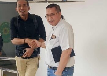 Advokat Hermanto Tambunan bersalaman dengan Advokat Niko Nixon Situmorang selaku penasehat hukum Roma Nasir Hutabarat. Keduanya saling ucapkan selamat usai kliennya divonis onslag vanrecht vervolging di PN Batam. (Sumber foto: JP - Batampena.com)