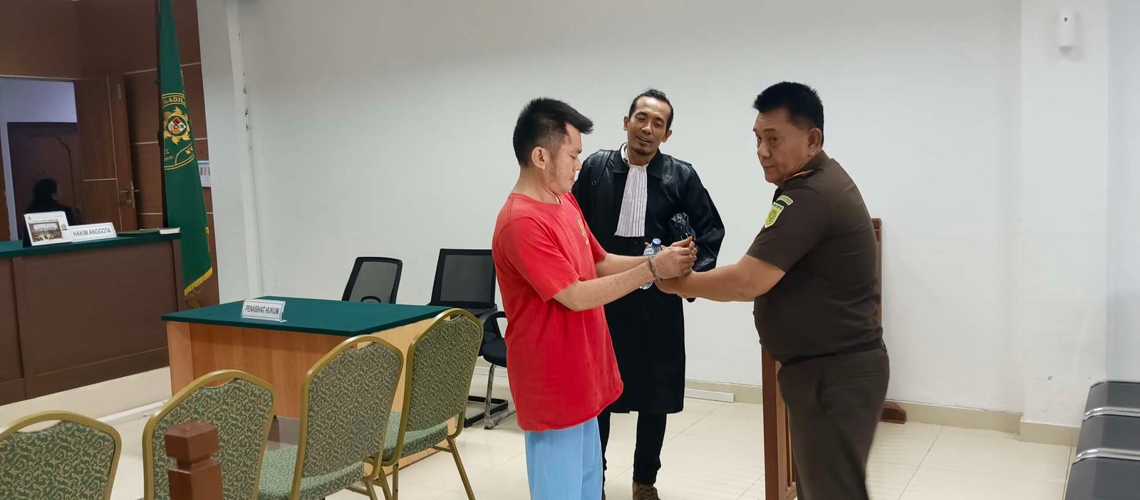 Advokat Hermanto Tambunan mendampingi Marianto alias Along yang sedang dipasangkan borgol oleh petugas Kejaksaan Negeri Batam.(Sumber foto: JP - BATAMPENA.COM)