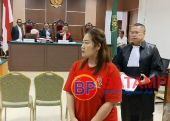 Terdakwa Nurmian Manalu meninggalkan ruang persidangan di PN Batam didampingi oleh penasehat hukumnya, Niko Nixon Situmorang. (Sumber foto: JP - BatamPena.com)