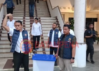 Penyidik Polresta Barelang membawa dokumen hasil penggeledahan di Gedung Direktorat Lahan BP Batam. (Sumber foto: JP - BatamPena.com)