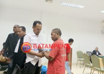 Terdakwa Rahman Padak sedang digari oleh petugas Kejaksaan Negeri Batam usai persidangan pembacaan vonis. (Sumber foto: JP - BatamPena.com)