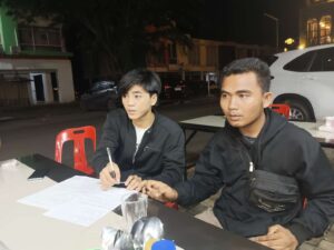 Regi Setiawan sedang memegang pena untuk menandatangani surat perjanjian damai dengan Joes Aldiansyah Butarbutar. (Sumber foto: JP - BatamPena.com)