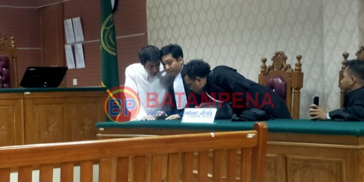 Wakil ketua Peradi Batam, Ahmad Rustam Ritonga berkonsultasi dengan penasehat hukumnya setelah divonis 2 tahun penjara oleh PN Batam. (Sumber foto: JP - BatamPena.com)